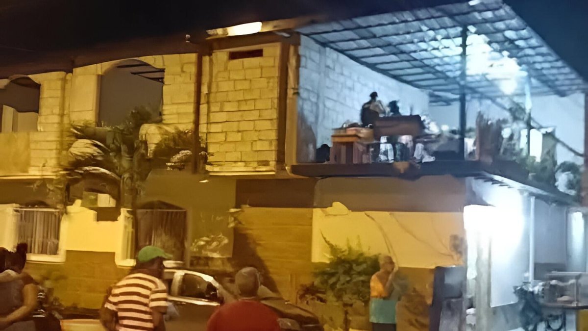 Vecinos observan desde la calle el lugar donde Dion Guevara, alias “Ñañón”, fue asesinado a tiros en el segundo piso de esta vivienda.