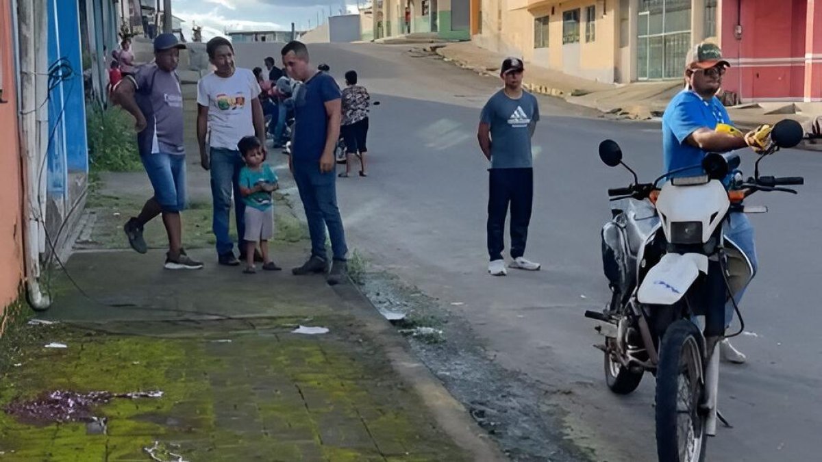 Vecinos del barrio El Rocío observan la escena acordonada por la Policía tras el ataque armado que dejó una mujer fallecida y otra herida.