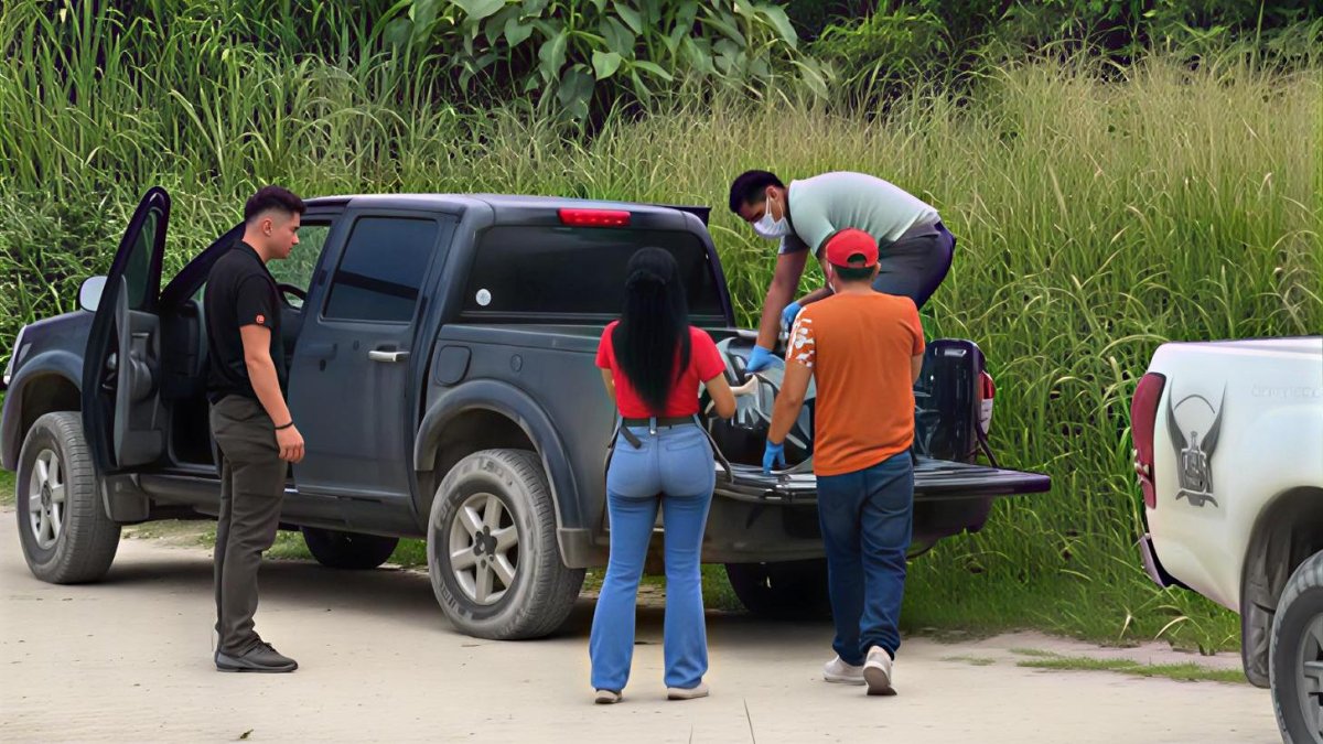 Agentes y moradores colaboran en el levantamiento del cuerpo hallado en la playa del recinto África, en medio de la conmoción que generó el hallazgo.
