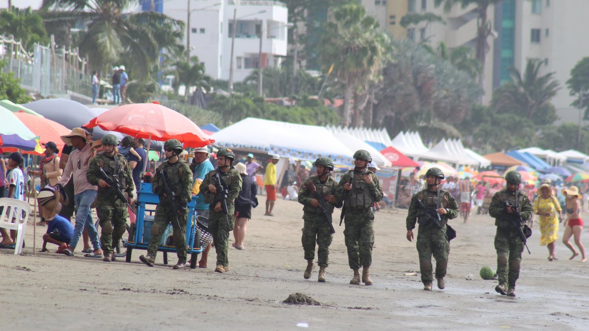 Militares de la Armada del Ecuador patrullan las playas de Atacames durante el feriado de Semana Santa, en medio de turistas y comerciantes, para reforzar la seguridad en el balneario.