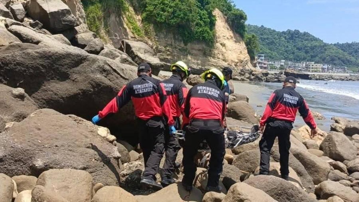 Rescatistas del Cuerpo de Bomberos de Atacames realizan la extracción del cadáver en el Peñón del Suicida.
