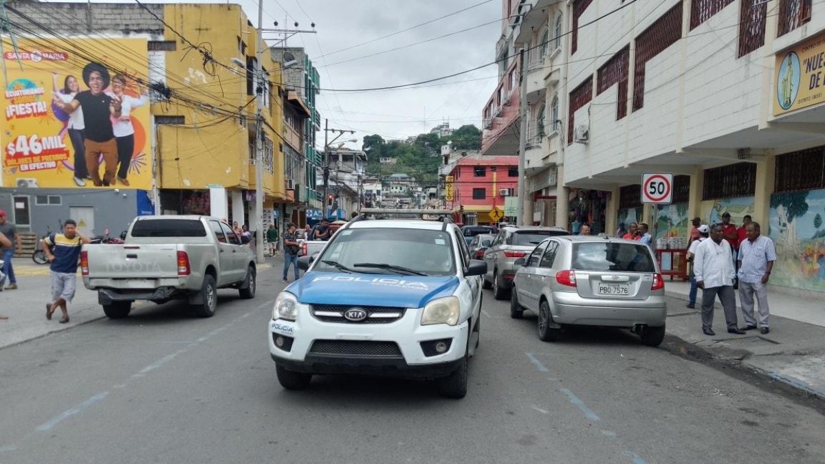 Patrulleros y transeúntes en la calle céntrica de Esmeraldas donde fue asesinado el empresario Édgar Aguayo, presidente de la Cámara de Comercio.