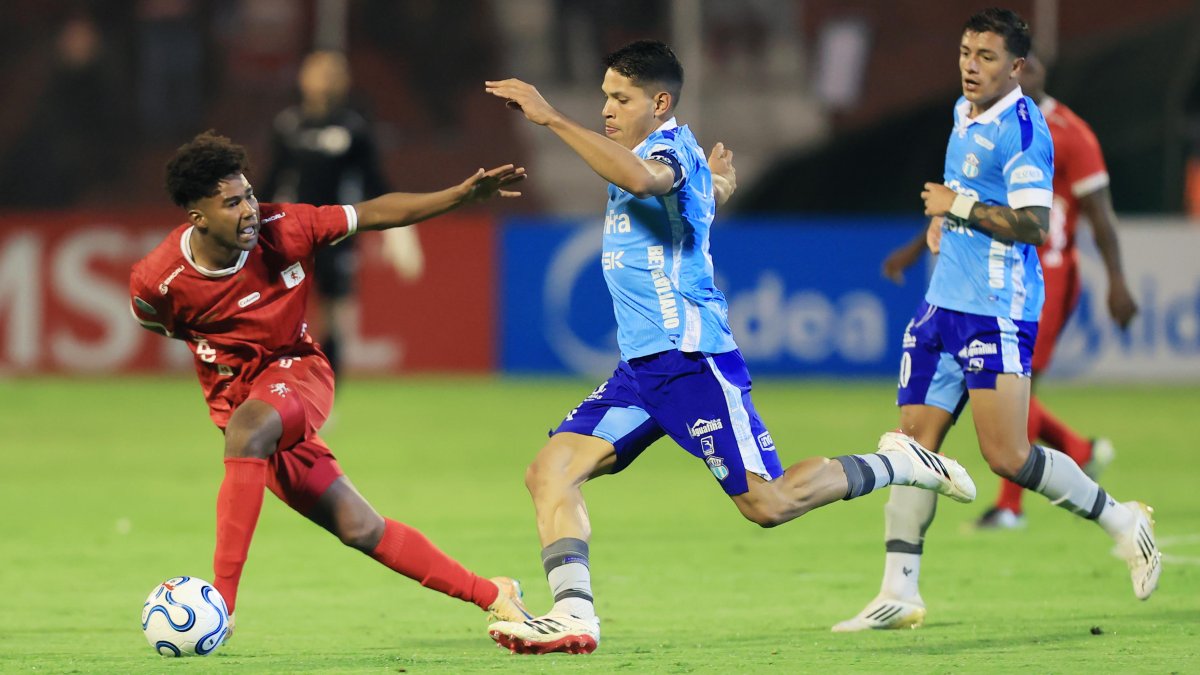 José Marrufo (c) de Macará disputa un balón con Jorge Valencia (i) de América .