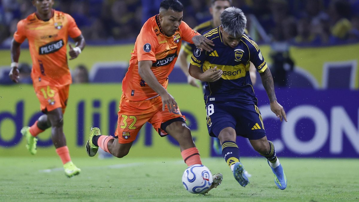 Milton Delgado (d) de Boca disputa el balón con Matías Lugo de Barcelona.