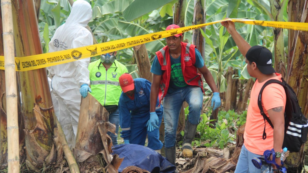 Personal de Criminalística retira el cuerpo de una de las jóvenes halladas sin vida en un canal de riego.