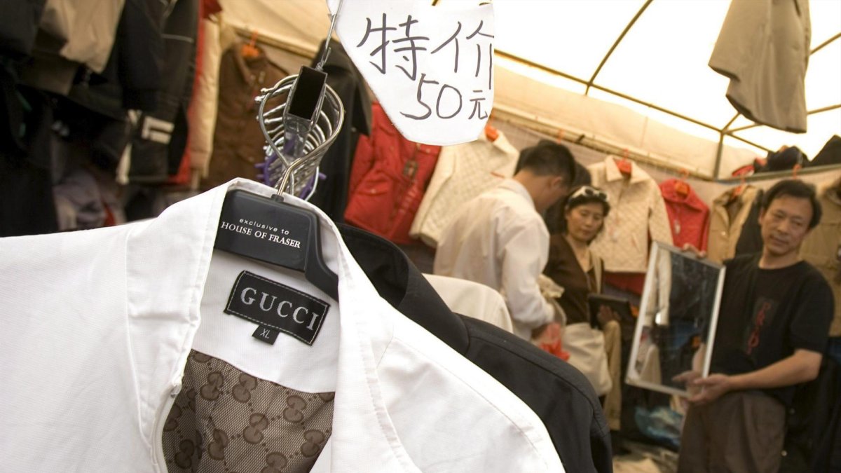 Vendedores en una tienda venden ropa falsificada