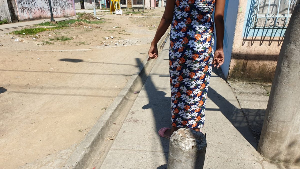 La tía de uno de los heridos señala el sitio donde ocurrió el hecho violento.