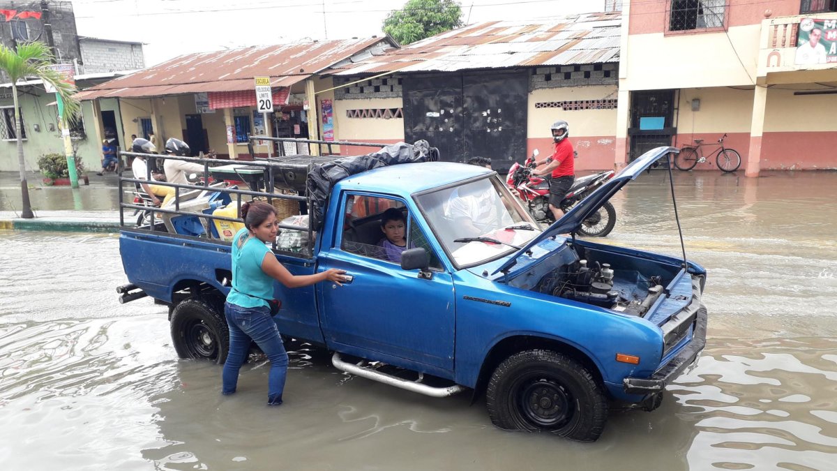 Dos personas empujaron su vehículo, que presentó daños por el ingreso del agua,  en la avenida 27 de Noviembre.