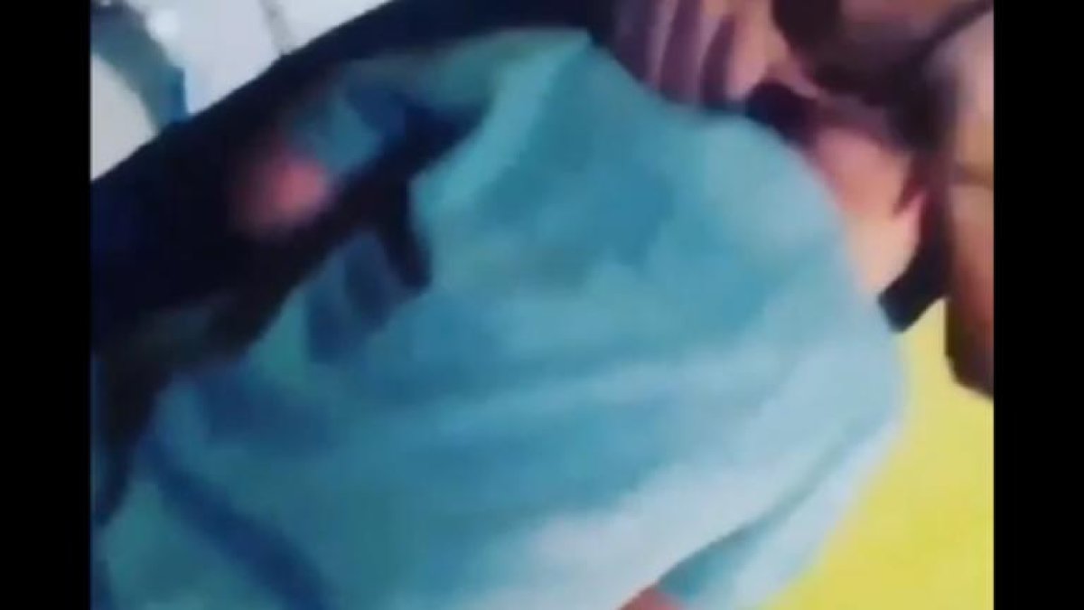 La mujer acerca al niño y coloca el cuchillo en su cuello.