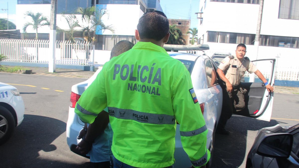 Un gendarme lleva al detenido al vehículo policial. El sujeto no presentó resistencia en su arresto.