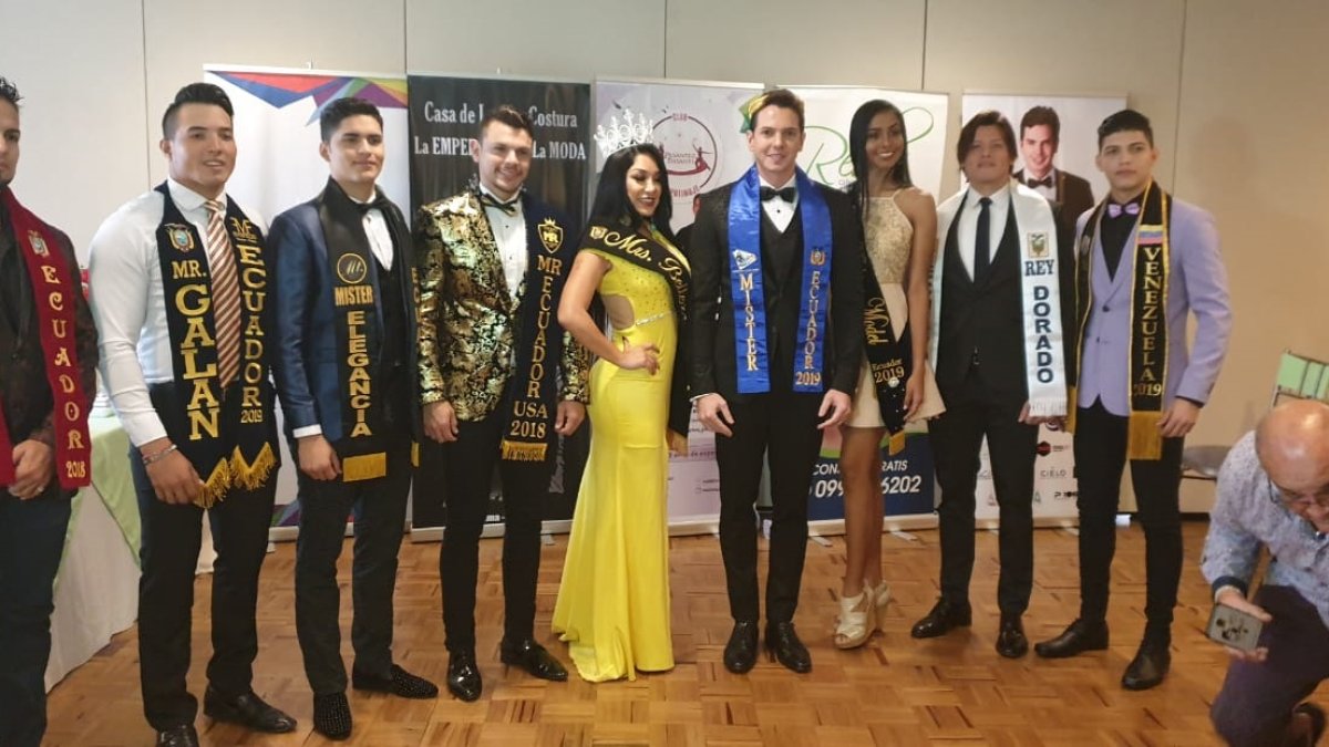 El ganador (al centro, junto a las modelos), con varios de los participantes en el concurso.