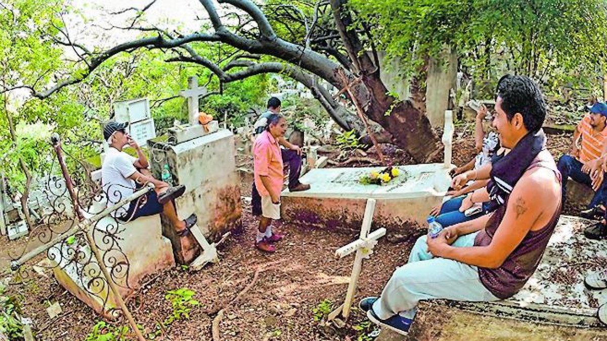Integrantes de un club de fútbol visitan la tumba de quien fue un jugador.
