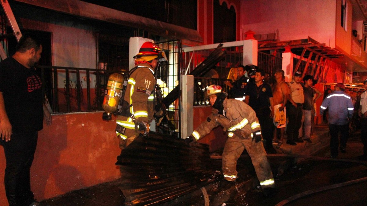 Los bomberos retiran las hojas de zinc calcinadas.