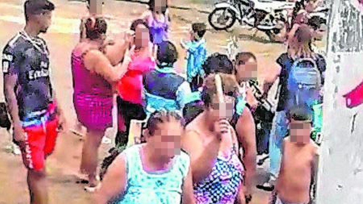 Enardecidos los habitantes le reclaman por su mal proceder.  Una señora sostiene en sus manos partes de un palo de escoba.