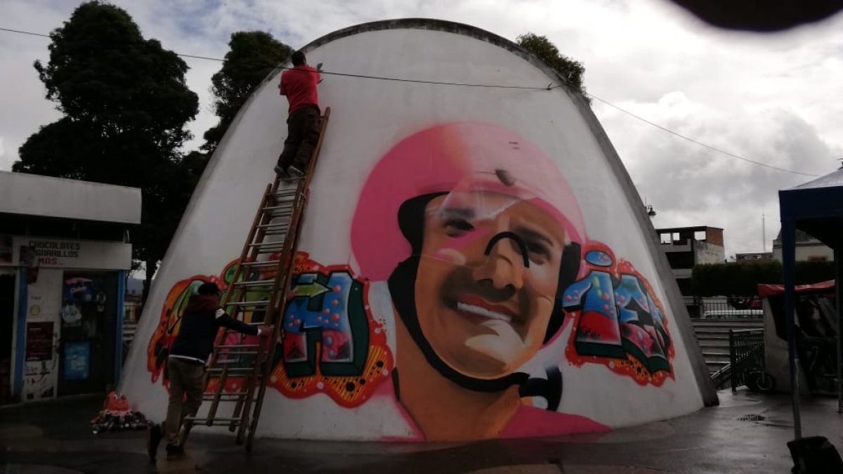 El artista da los retoques finales a su obra, con un Richard Carapaz sonriente.