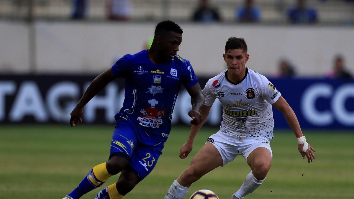 Alejandro Villalva (i) de Delfín disputa un balón con Eduardo Fereira de Caracas durante un partido de la Copa Libertadores entre Delfín de Ecuador y Caracas de Venezuela, en el estadio Jocay en Manta (Ecuador).