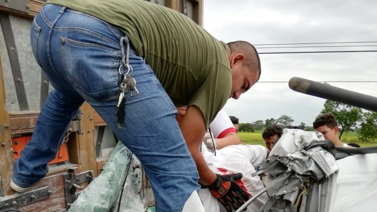 Personal de rescate ayuda a liberar el cuerpo de la víctima, atrapado en la cabina de su vehículo.