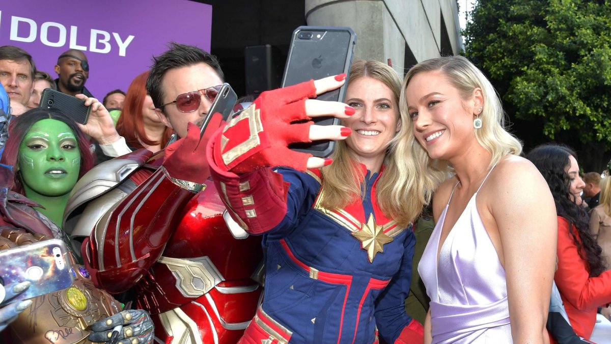 Brie Larson posa con unos fanáticos a la llegada al evento.