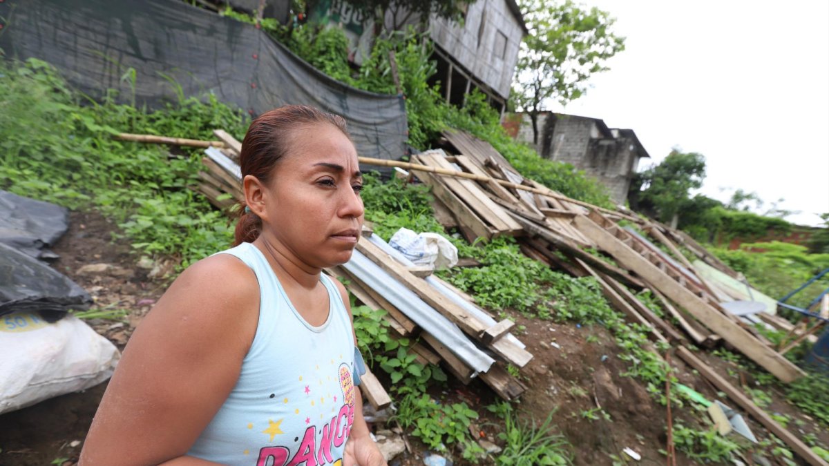 Martha Cedeño Mite en el predio donde estaba su casa. De eso solo quedan maderos y planchas de zinc.