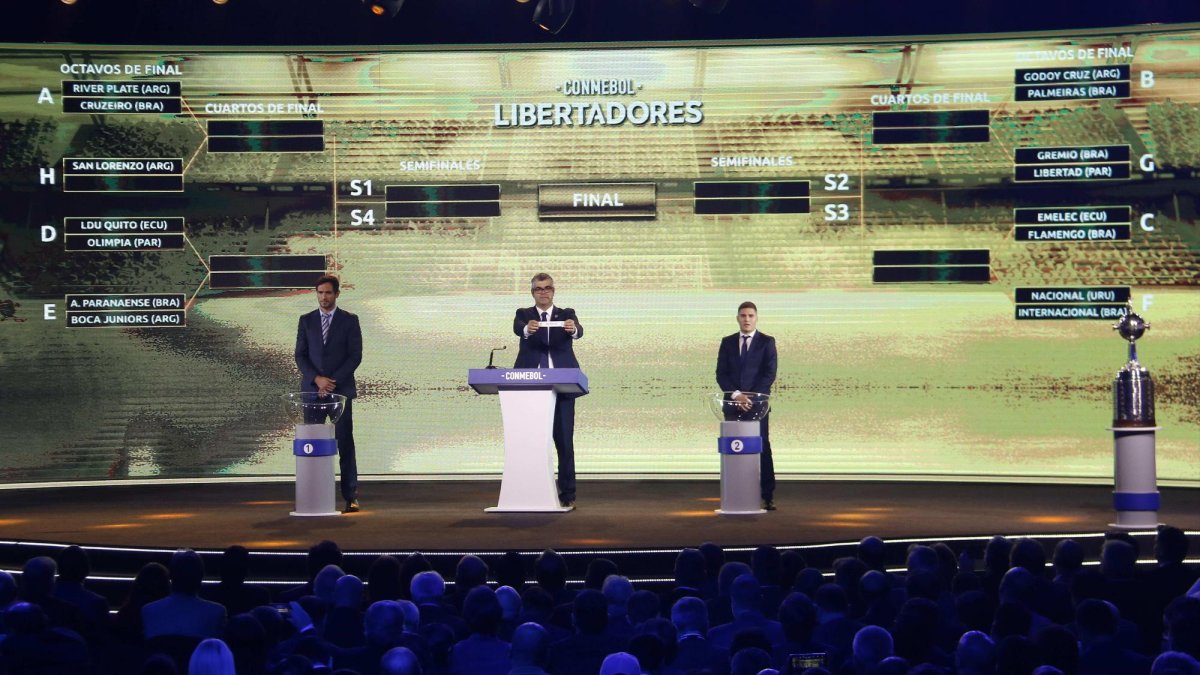 El director de competiciones de la Confederación Sudamericana de Fútbol (Conmebol), Federico Nantes, y los futbolistas el paraguayo Roque Santacruz (i) y el colombiano Juan Fernando Quintero participan en la gala del sorteo.