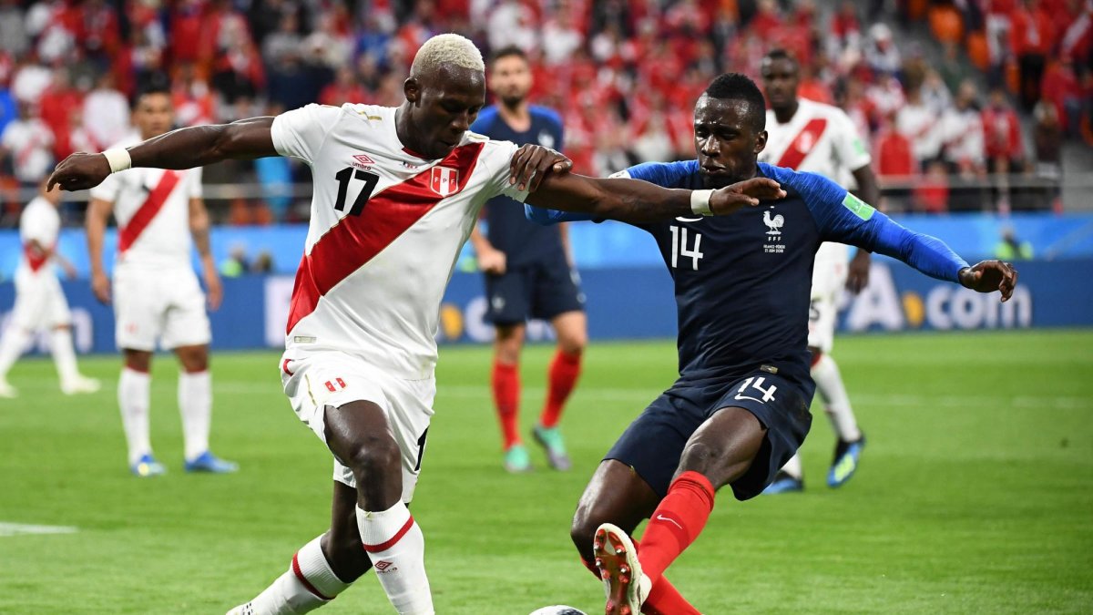 El defensor peruano Luis Advincula (L) compite por el balón con un jugador de Francia.
