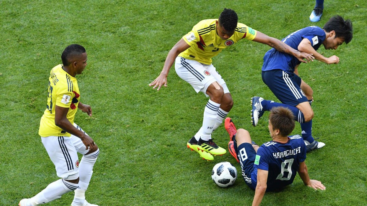 El centrocampista colombiano Wilmar Barrios compite con el delantero japonés Genki Guaraguchi.