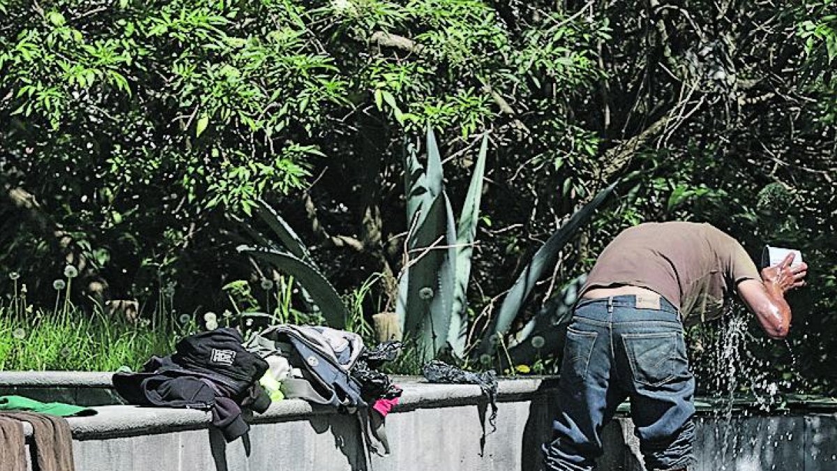 Personas en situación de calle se bañan y lavan su ropa en las piletas del lugar.