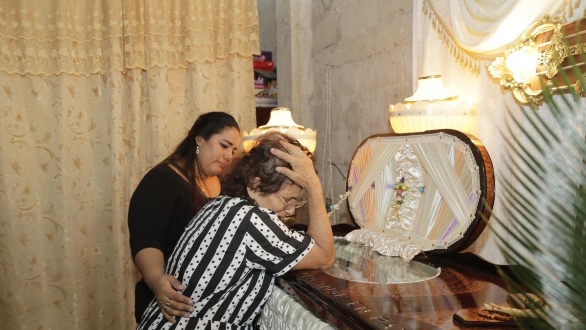 Amada Briones es consolada por su nieta Yulli Villamar. La señora le pedía a su hija que se levante y le hable.