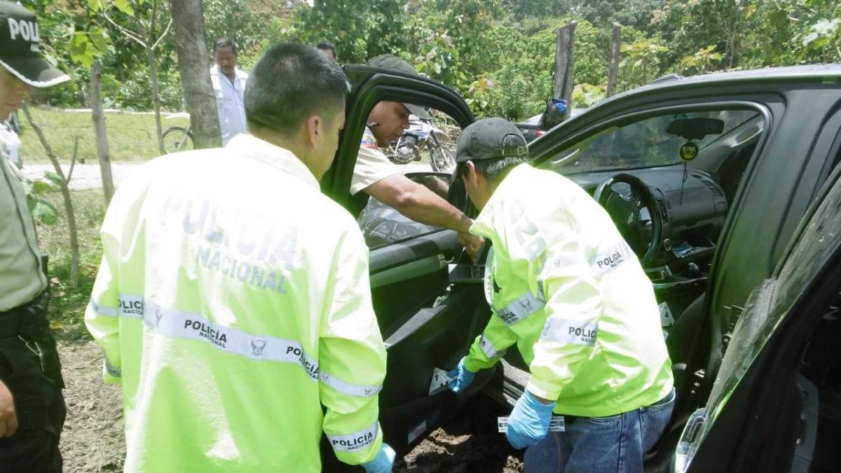 Agentes inspeccionan el vehículo de los presuntos delincuentes.