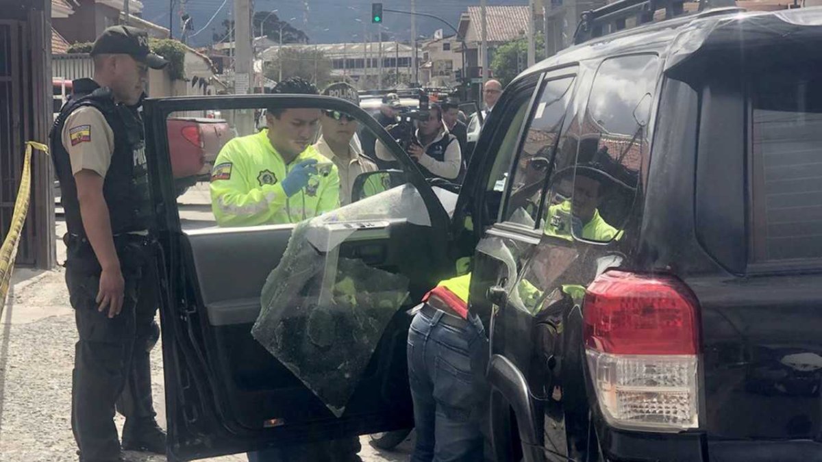 Agentes policiales revisan el auto de la persona atacada por sacapintas.