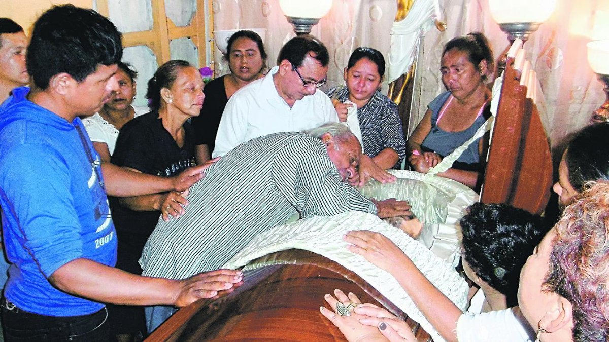 Momento en que Gustavo Salas llora junto al féretro de su nuera Vanessa, quien fue baleada la noche del sábado presuntamente por su esposo.