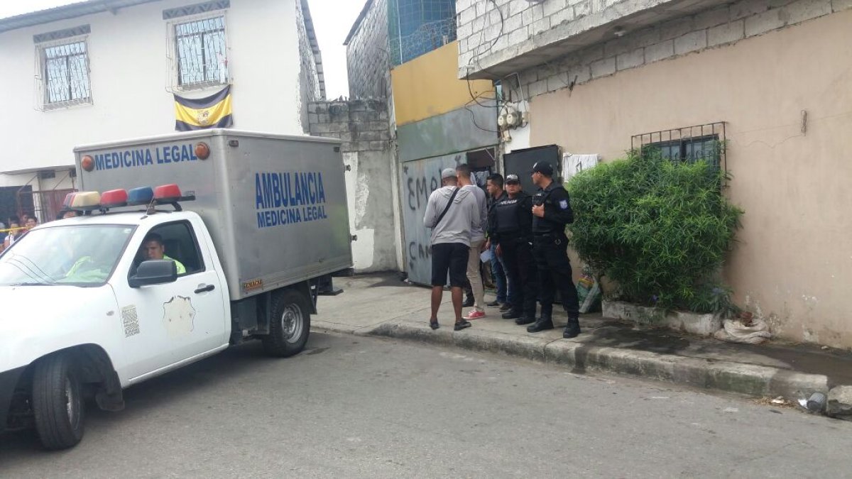 Agentes de medicina legal transportan el cadáver.
