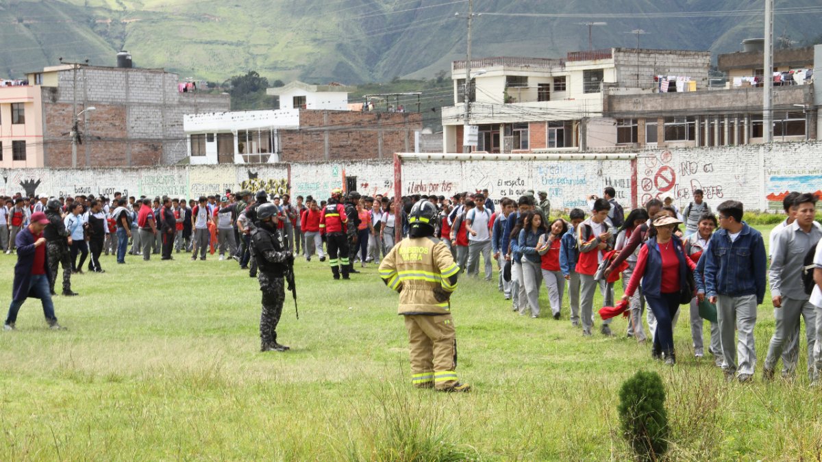 Personal de emergencia realiza la evacuación de los estudiantes.