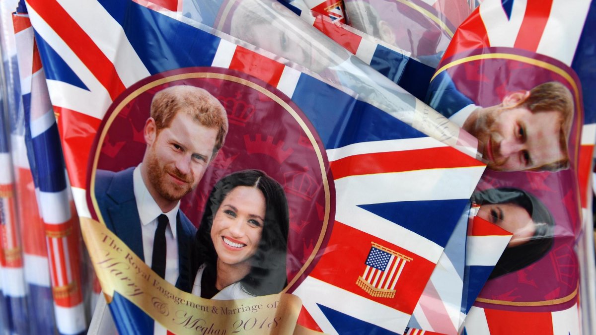 Bandera británicas con la imagen del príncipe Enrique y su prometida Meghan Markle son puestas a la venta en Windsor.