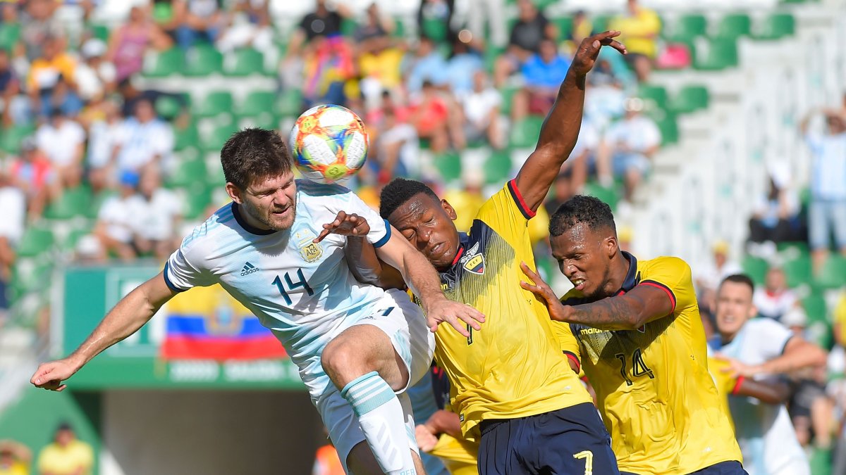 El defensa ecuatoriano Pervis Estupiñán (7) disputa el balón con el argentino Walter Kanemann (14).