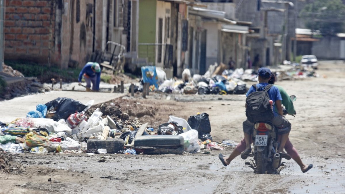 Los conductores y transeúntes deben sortear los baches llenos de agua y los ‘cerros’ de basura.