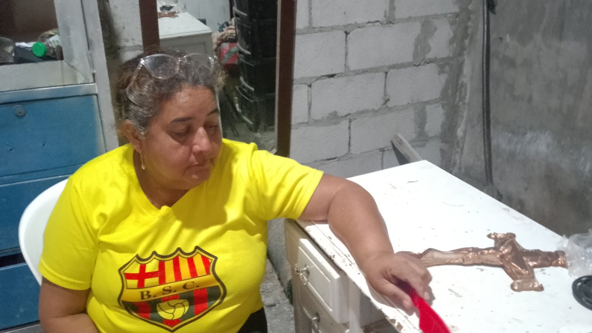 La madre se aferra a un crucifijo para pedirle a Dios que le traiga a su hijo con vida.