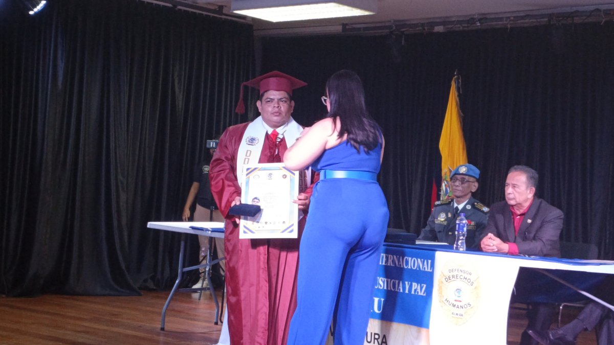 Momento en que el abogado Paúl Moreno, de 35 años, recibe el título de doctorado honoris causa.