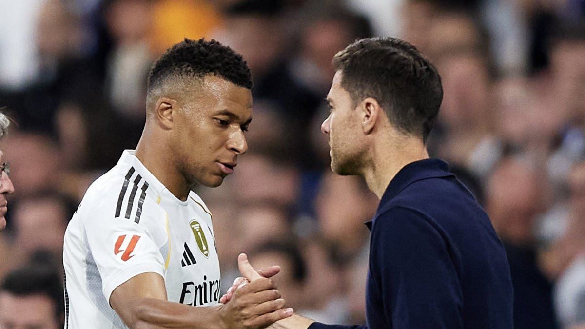 Kylian Mbappé y Xabi Alonso intercambian saludos.
