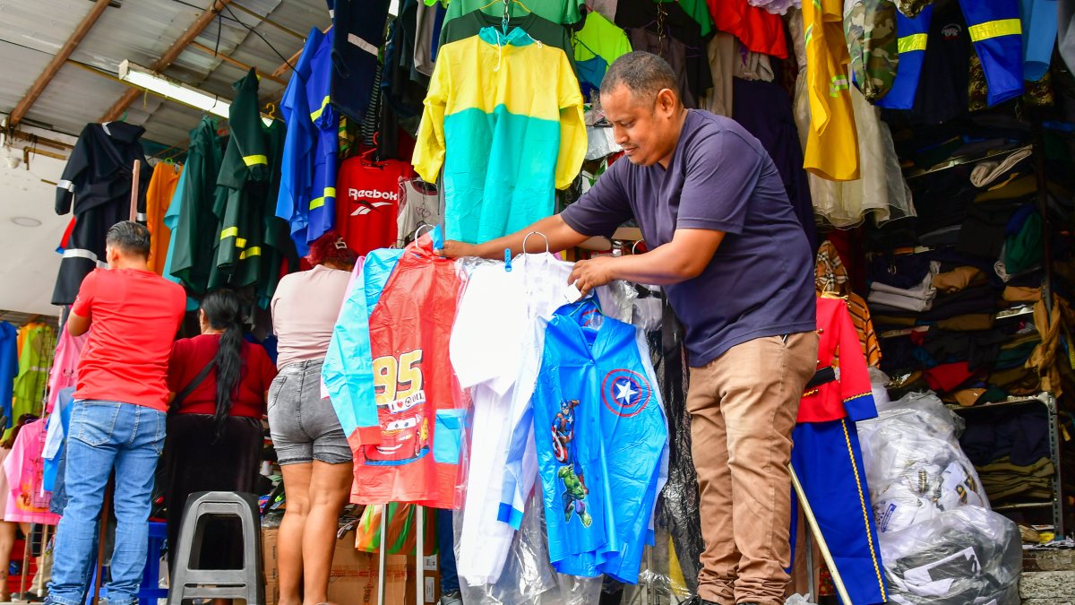 Diego Calderón muestra los impermeables con estampados para niños que comercia.