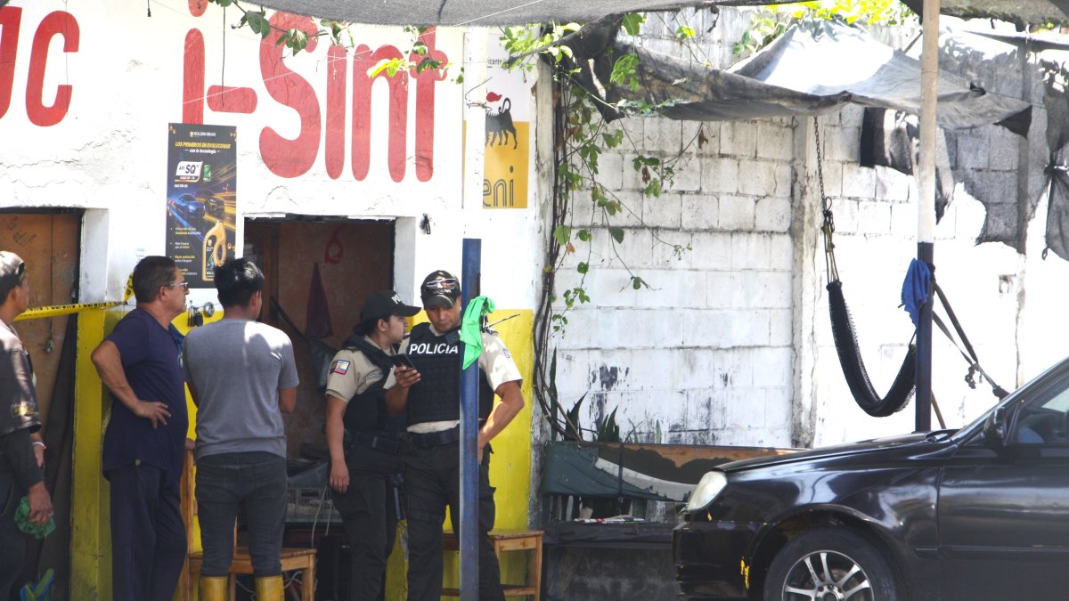 Los policías levantan evidencias en el lugar del crimen.