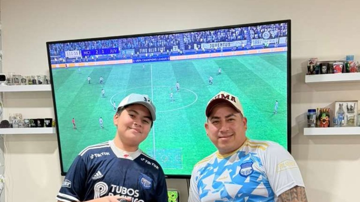Ahidam (i) y su padre comparten la afición por Emelec y el fútbol hasta en los videojuegos.