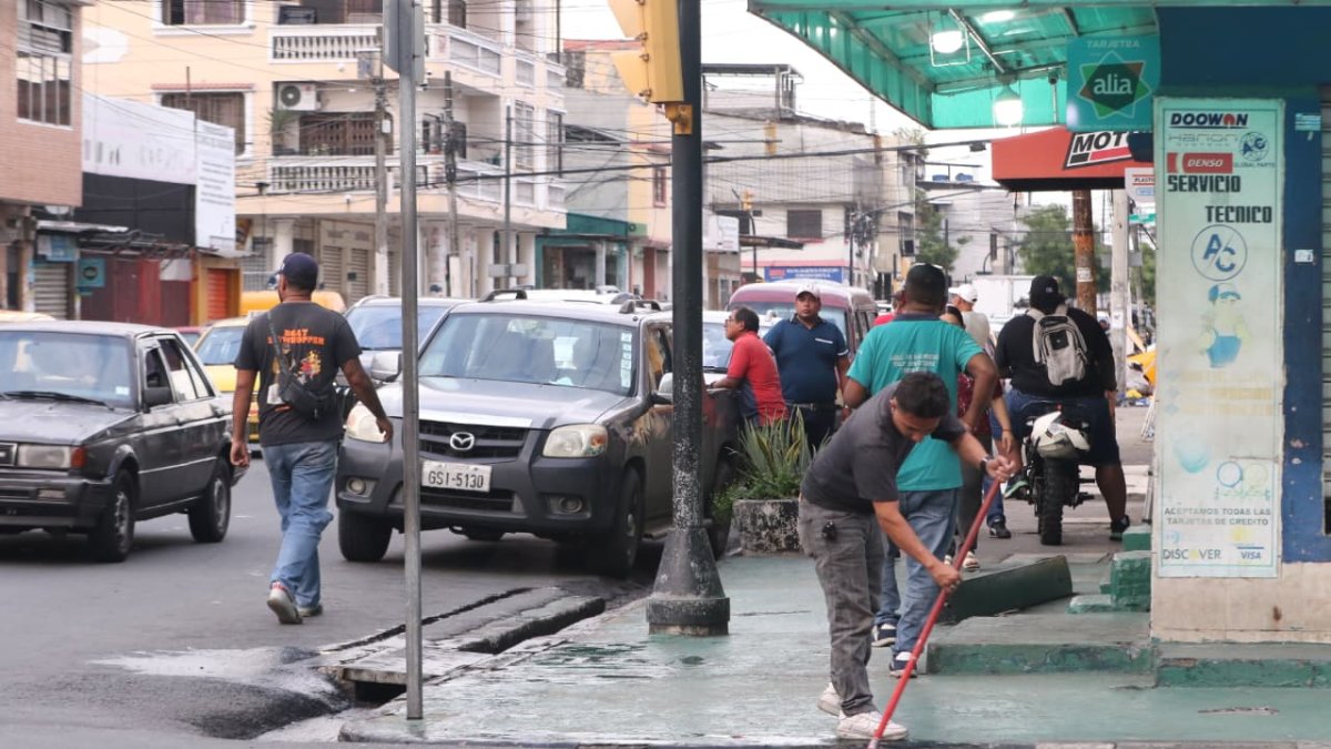 Moradores del sector limpiaban la sangre que quedó en el asfalto tras el crimen.