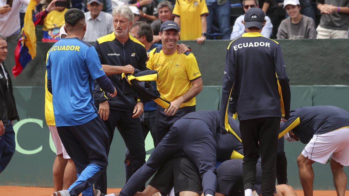 Jugadores e integrantes del cuerpo técnico de Ecuador celebran la clasificación a la segunda ronda tras ganar ante Australia el partido de dobles.