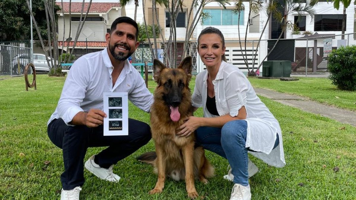 La pareja muestra la ecografía del bebé que viene en camino. Junto a ellos el perro que adoptaron.