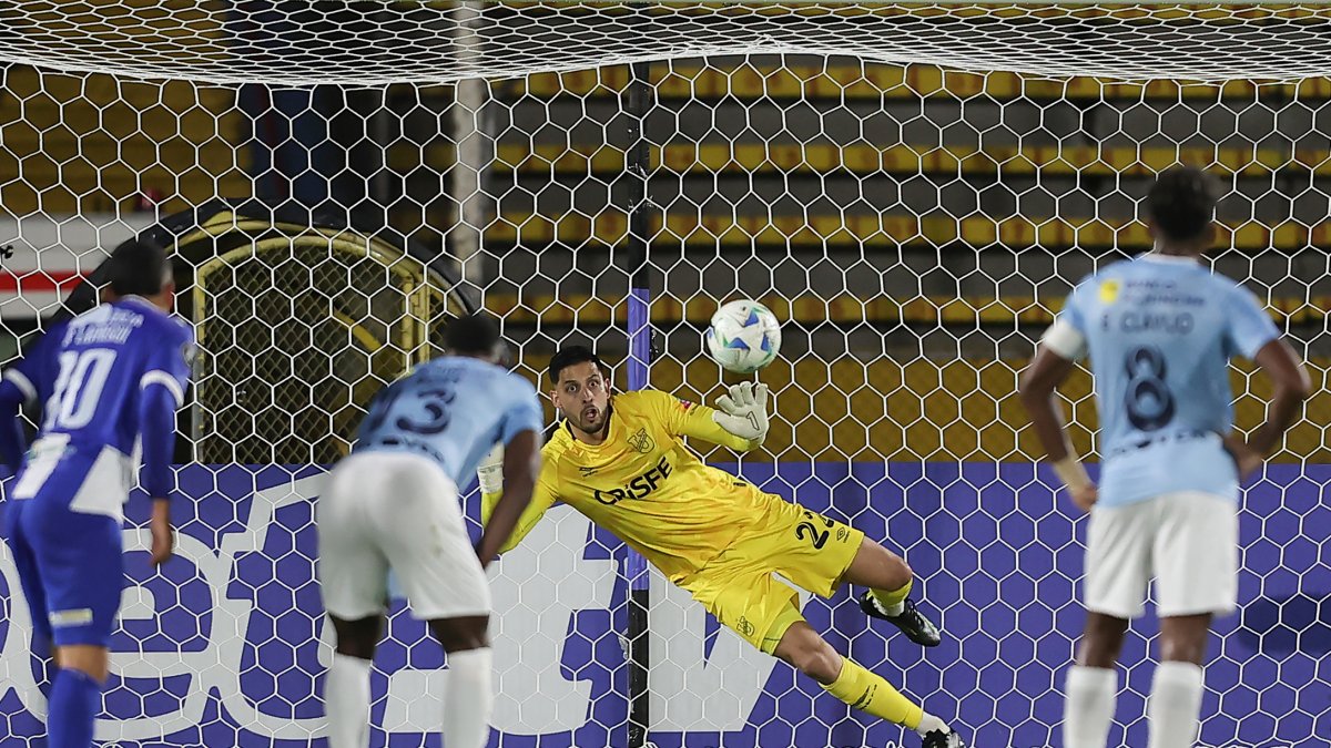 Rafael Romo (c) de U. Católica se lanza por el balón en la tanda de penales en el partido de vuelta por la primera fase de la Copa Libertadores ante Juventud.