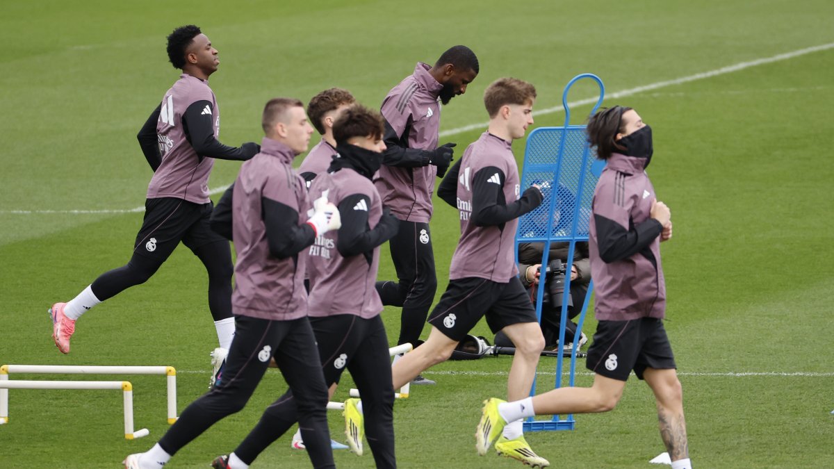 El delantero del Real Madrid Vinicius (L, al fondo) durante el entrenamiento del equipo en la Ciudad Deportiva de Valdebebas.