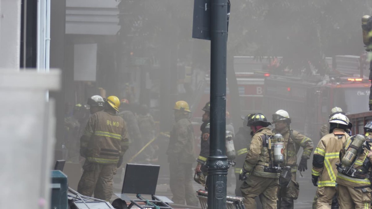 Bomberos trabajan en la extinción de un incendio que afectó tres locales en el centro de Guayaquil