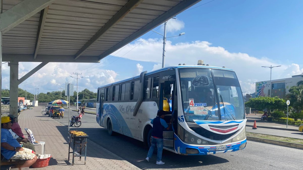 En la parada del puerto de Esmeraldas, un bus de la coop. Las Palmas recoge pasajeros en medio de la dinámica urbana y el comercio callejero.