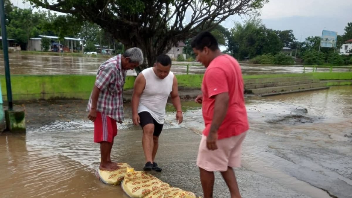 Pobladores de la parroquia Vernaza colocan sacos con arena para tratar de contener el agua.